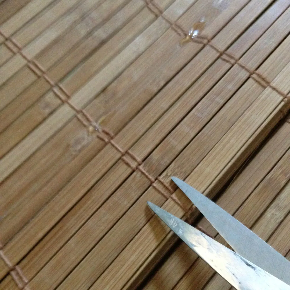 scissors trimming cords on diy bamboo blinds