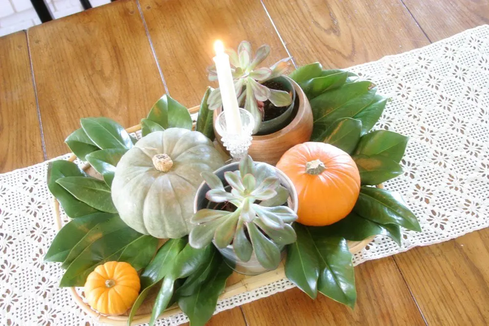 thanksgiving centerpiece with magnolia leaves and pumpkins