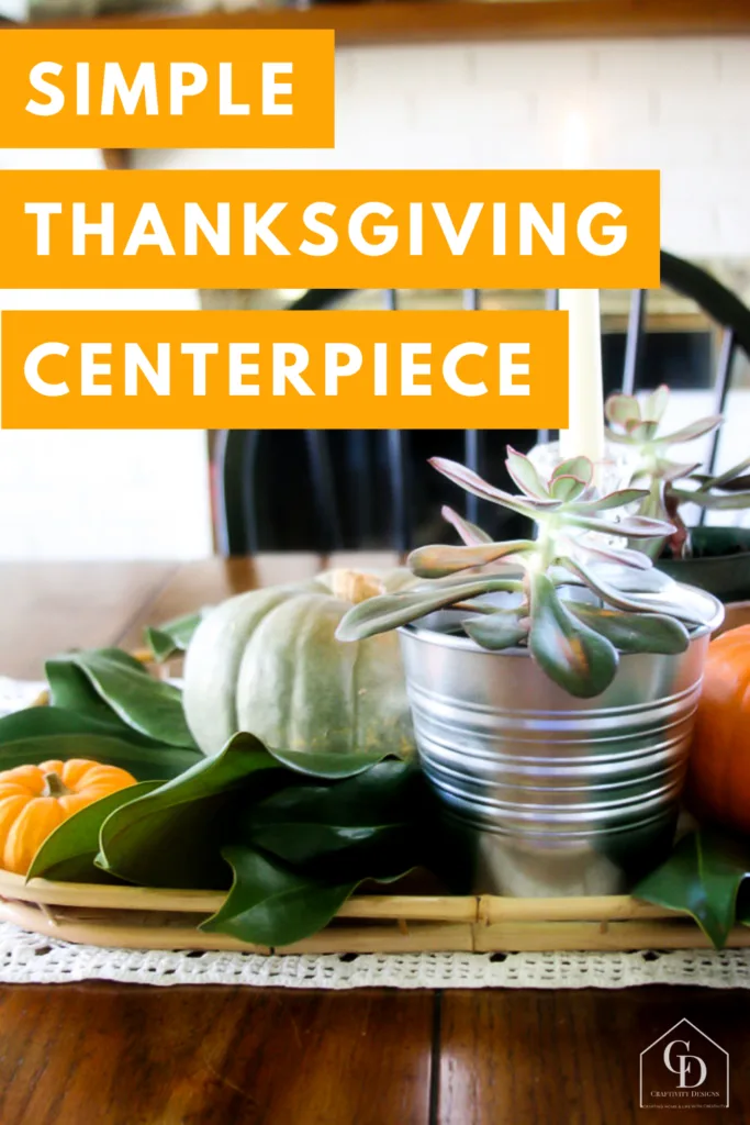simple thanksgiving centerpiece with pumpkins, succulents, magnolia leaves, and candles