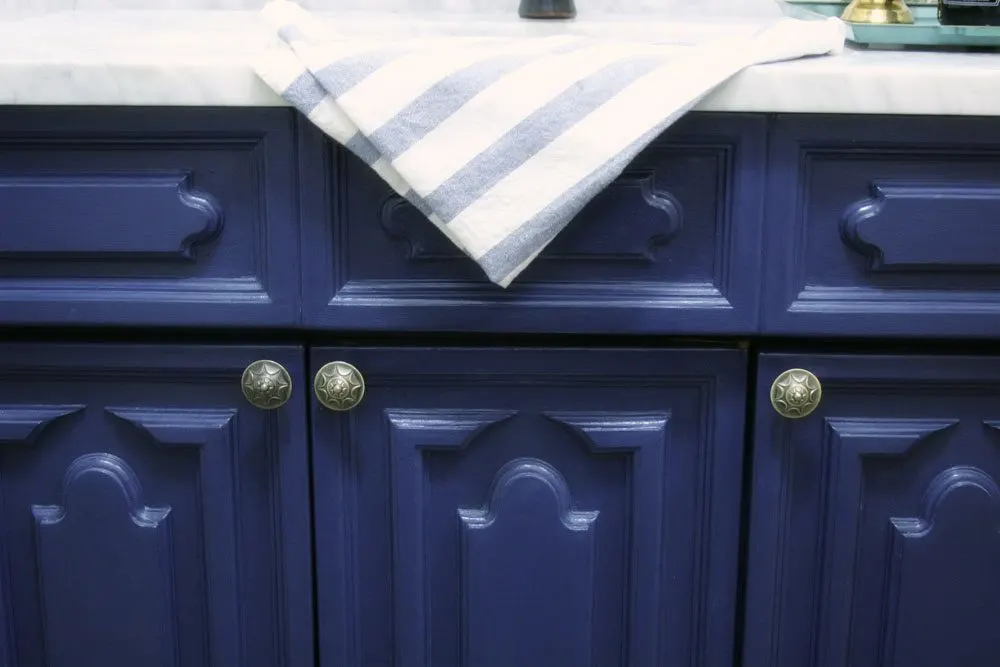 Navy blue vanity with brass knobs used for a bathroom vanity makeover. 
