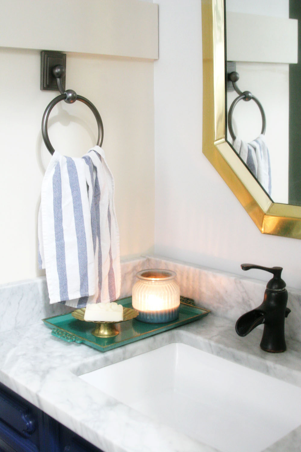 Navy and white bathroom renovation with vintage art, marble, board and ...