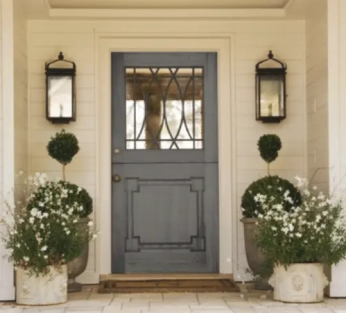 A cream home exterior with a grey door and concrete planners for a front door idea