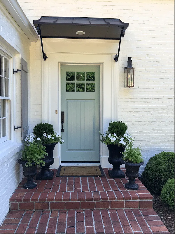 Home with white painted brick and a grey-blue door idea