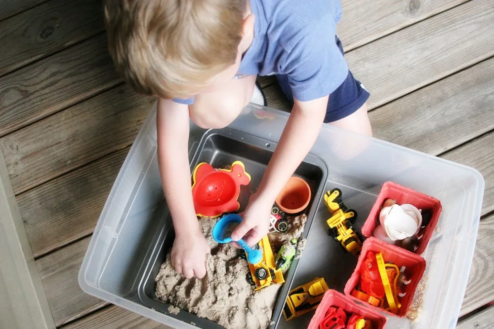 Boy playing with a DIY portable sandbox