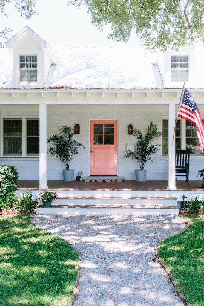 Home with painted brick exterior, a pink front door idea and metal planters