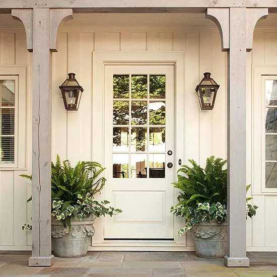 A white home with a white front door idea and concrete planters