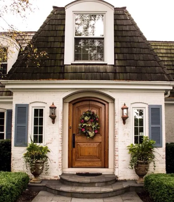 Home with white painted brick and a wooden door idea