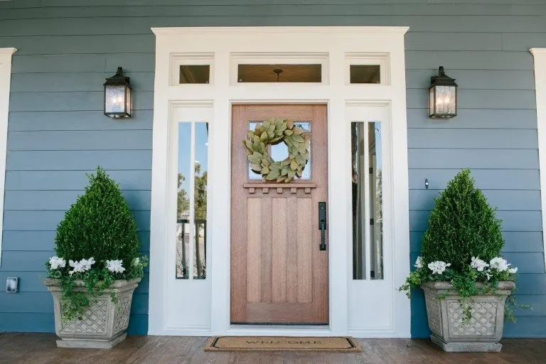 Home with blue-gray siding and a wooden door idea.