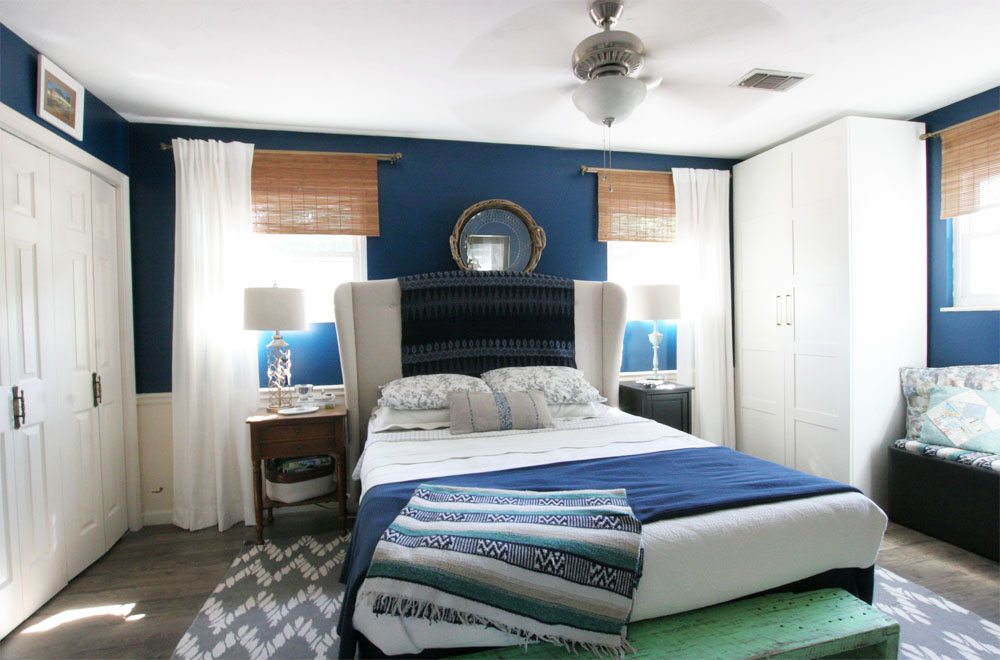 Navy Master Bedroom: navy walls, upholstered headboard, custom wardrobes, white bedding, upholstered ottoman, white curtains, bamboo blinds by @CraftivityD