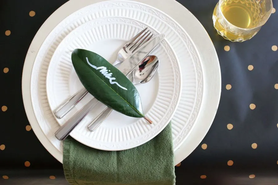 Elegant Christmas Table Setting with black, gold and a magnolia leaf place card