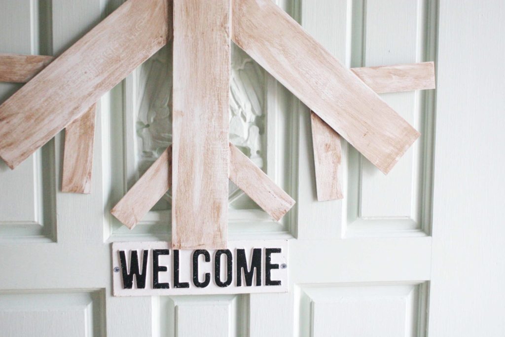 Front door with giant wood snowflake wreath. 