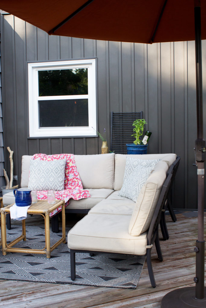 Revestimiento de Listones y tableros de color gris Oscuro (Revestimiento Vertical) y Muebles de patio para exteriores en una cubierta