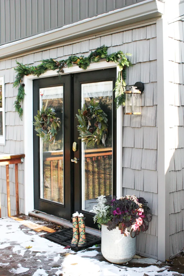Black Door with Christmas Wreaths and Garland and Gray Cedar Shake Vinyl Siding Accent
