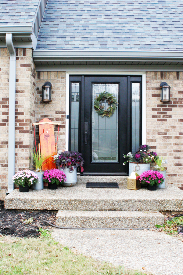 A Modern Christmas Cottage with a Brick Exterior, Black Front Door, Black Shutters, and Gray Siding