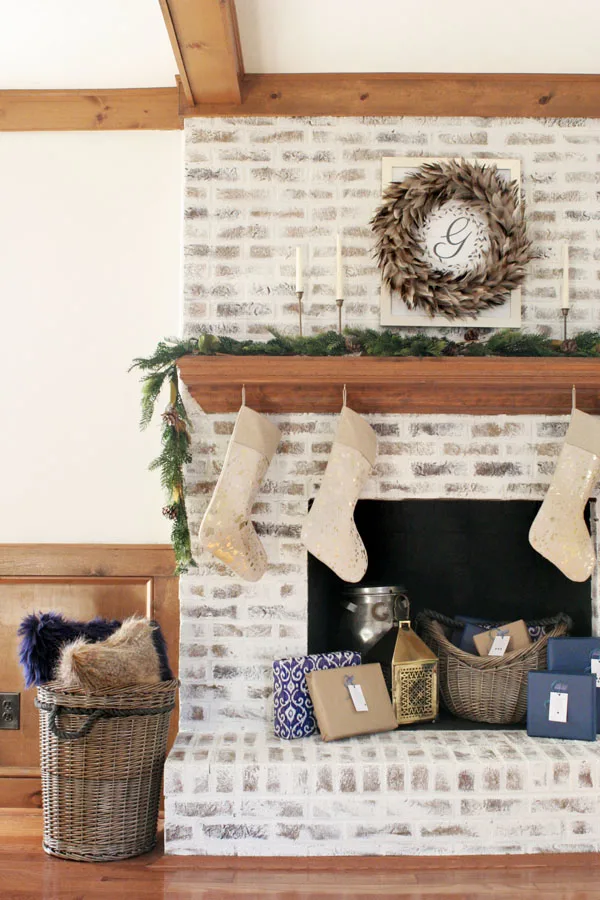 German Schmear Brick Fireplace with Christmas Decorations - Feather Wreath, Brass Candles, and Garland. Christmas Mantel Ideas on a German Schmear Brick Fireplace.
