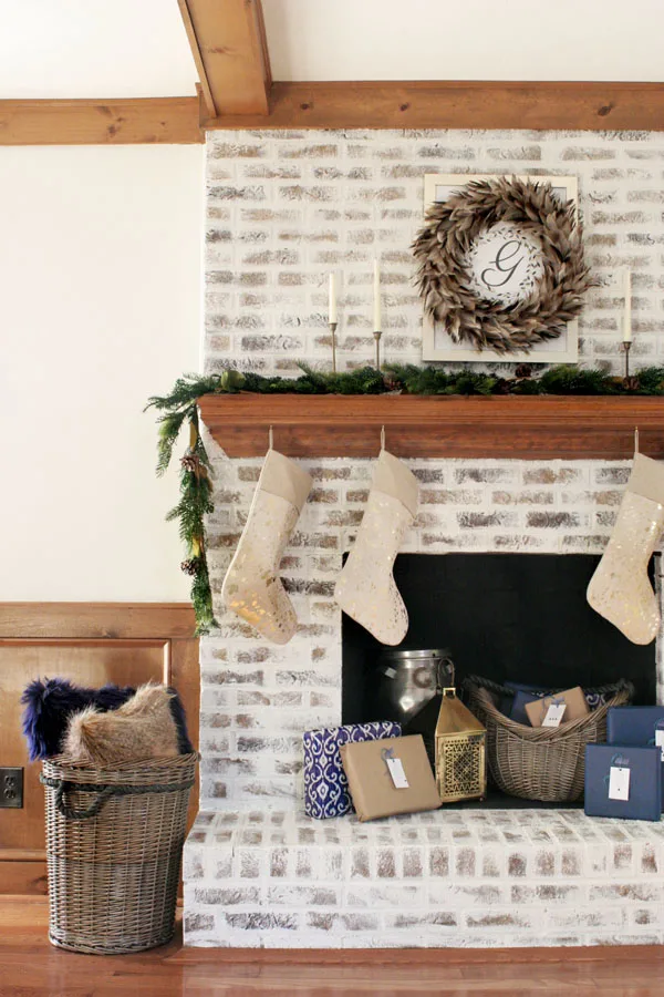 Christmas Fireplace Decorations and Christmas Mantel Ideas including gold stockings, blue Christmas decor, and a white brick fireplace.