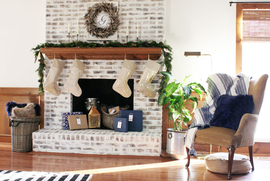 Christmas Fireplace Decorations and Christmas Mantel Ideas including gold stockings, blue Christmas decor, and a white brick fireplace.