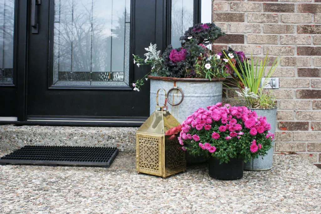 Christmas front porch decor with a brass lantern and pink flowers