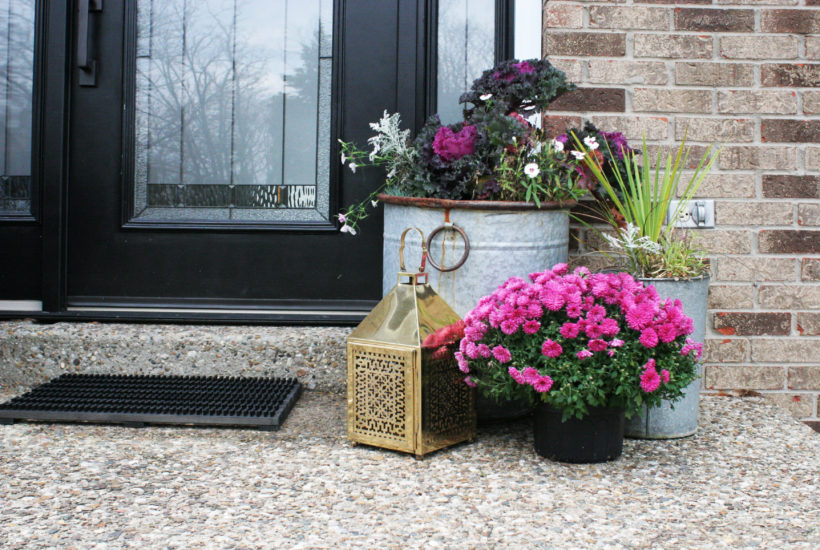 Christmas front porch decor with a brass lantern and pink flowers