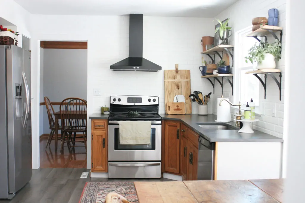 kitchen with white walls, brick backsplash, and dark gray countertops