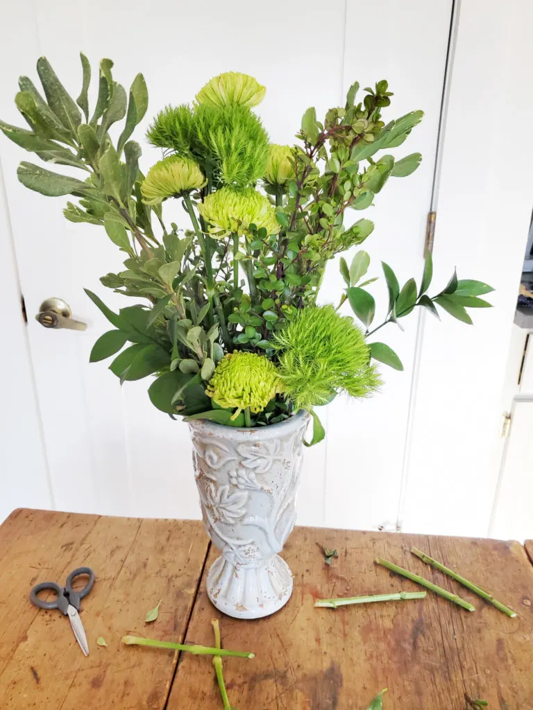 how to assemble a green flower arrangement, step 3, insert tall flower stems in center