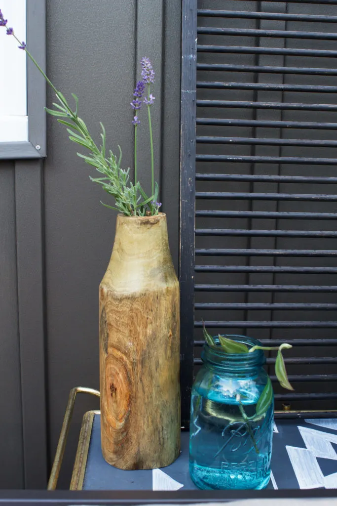 lavender in a wood vase, mason jar with clipping, and dark vinyl siding