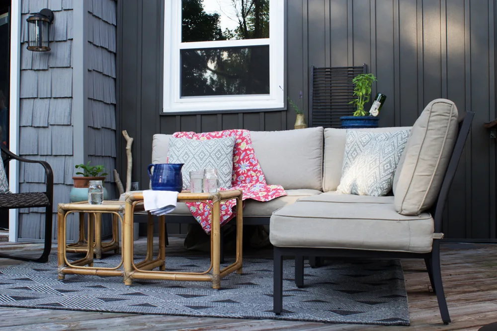 back porch, deck, with neutral sectional and vintage bamboo tables
