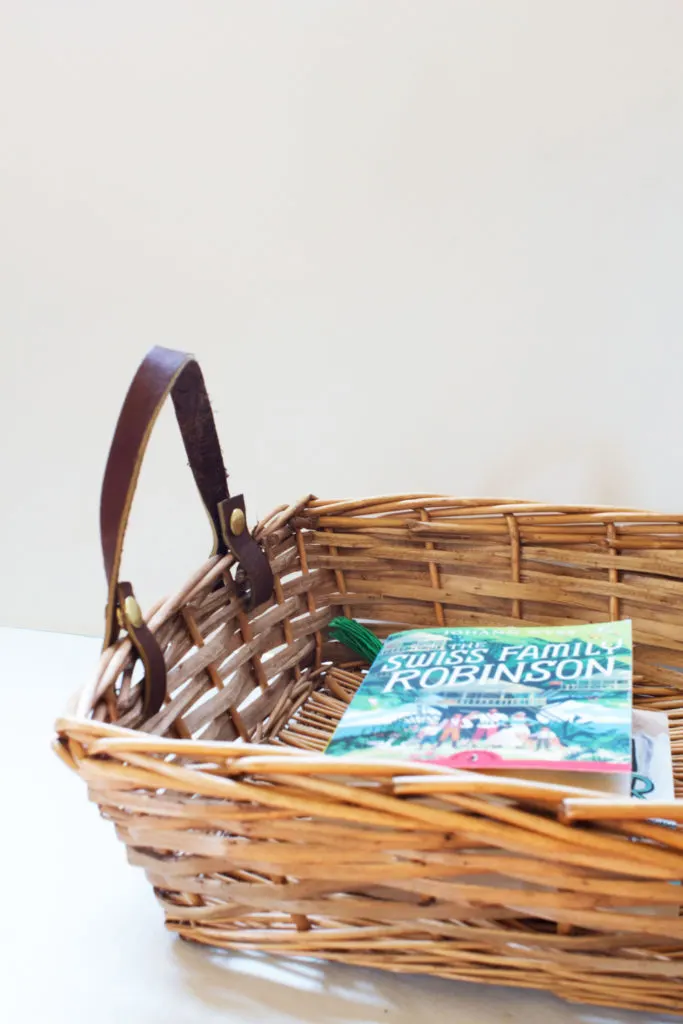 wicker basket with leather handles filled with library books