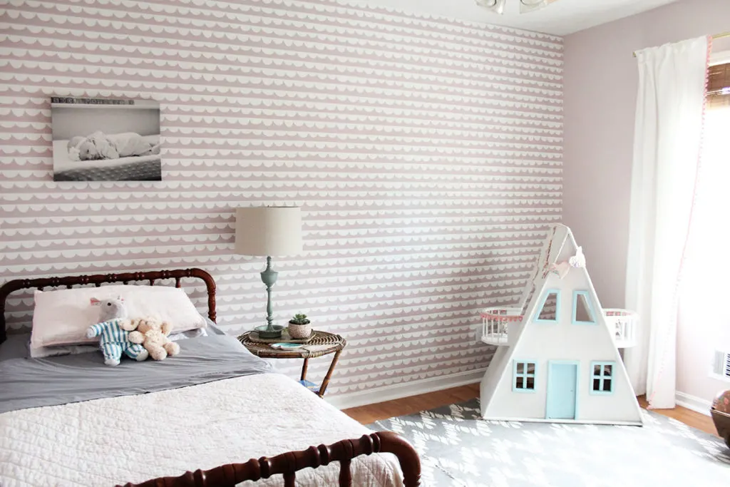 A Pink Girls Bedroom with antique bed, dollhouse, and gray rug by Craftivity Designs