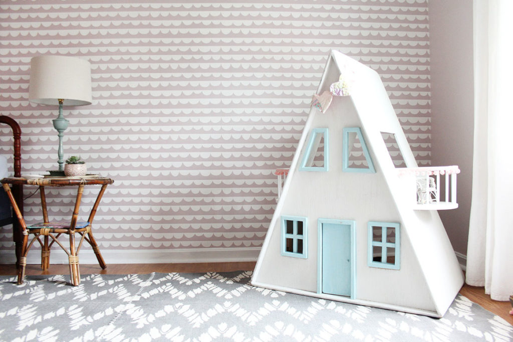 A Pink Girls Bedroom with rattan night stand, dollhouse, and gray rug by Craftivity Designs