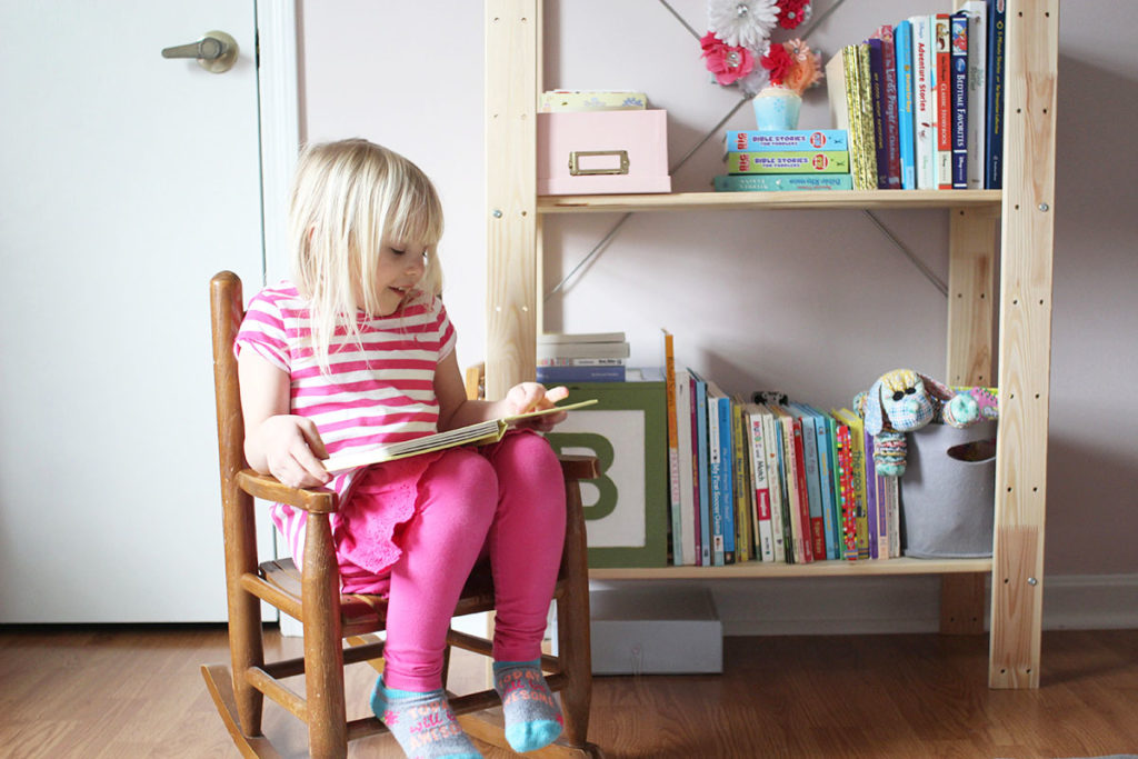 Child reading book in vintage rocker next to bookshelf, by Craftivity Designs