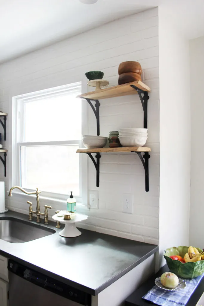Budget kitchen remodel with reclaimed wood shelves and a brick backsplash