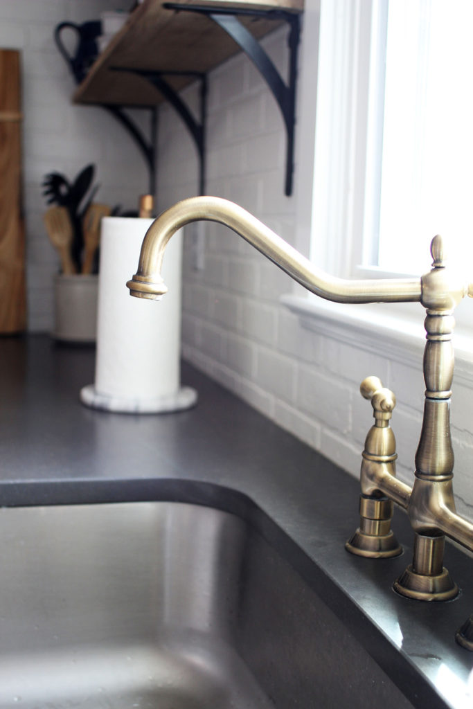 Brass faucet and dark quartz counter