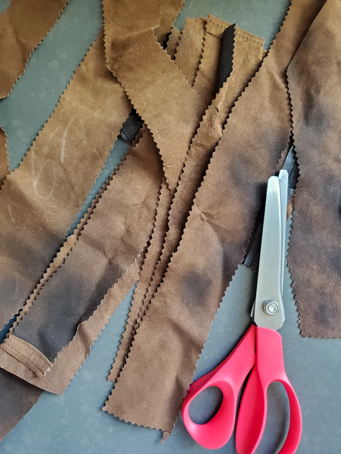 cut strips of leather with shearing scissors