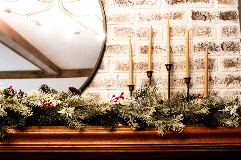 german smear fireplace, candles and greenery on Christmas mantel