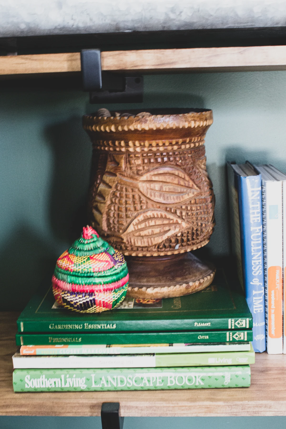 Global eclectic decor on shelves in green master bedroom