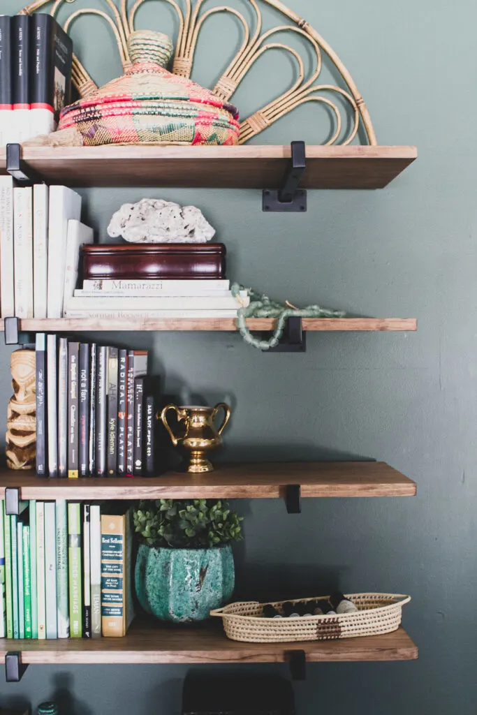 Global eclectic decor on heavy duty wall shelves in green master bedroom, heavy duty shelf brackets