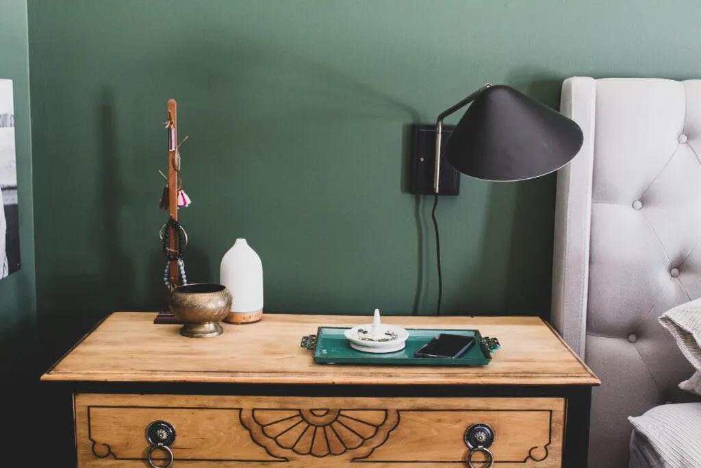 nightstand organization and dark green bedroom walls