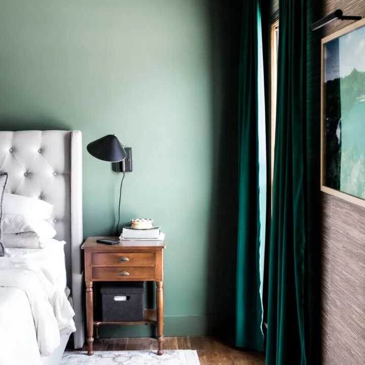 dark green bedroom walls with dark green curtains and brown grasscloth wallpaper accent wall