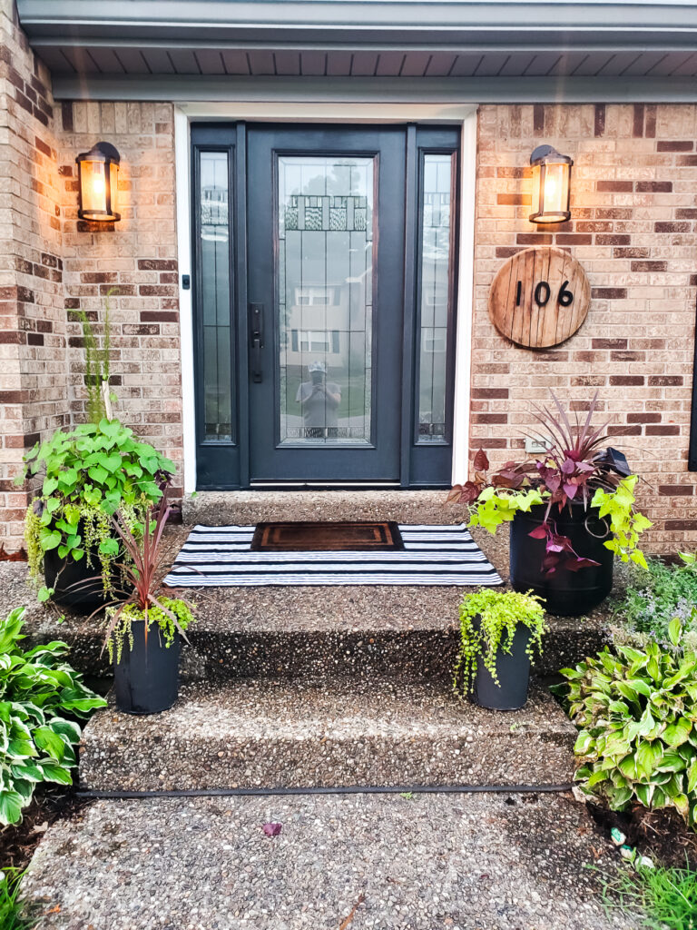 small front porch ideas - planters, layered rugs