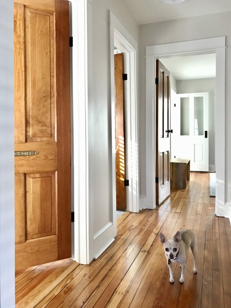 hallway with white trim and stained doors