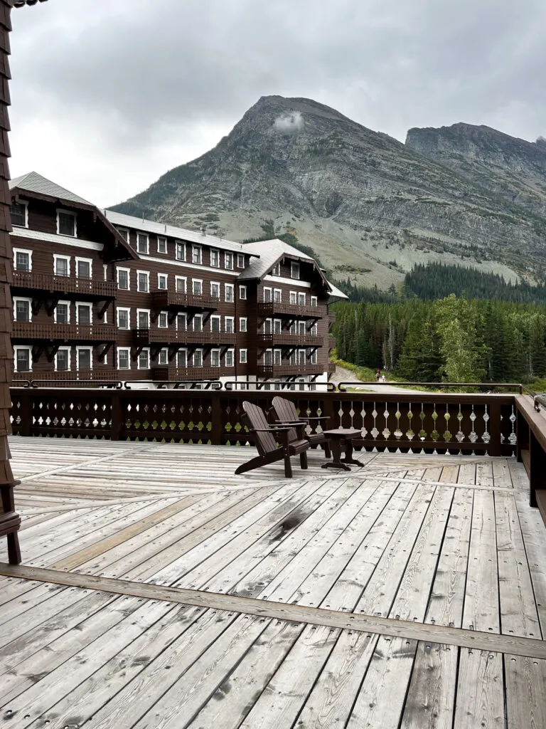 Deck at Many Glacier Hotel with Adirondack Chairs facing Swiftcurrent Lake