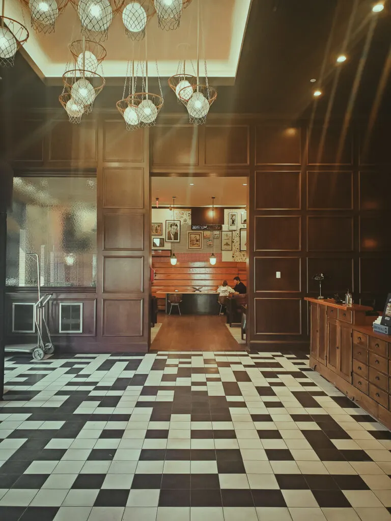 lobby graduate bloomington review, basketball chandelier, black and white tile, antique wood check-in counter