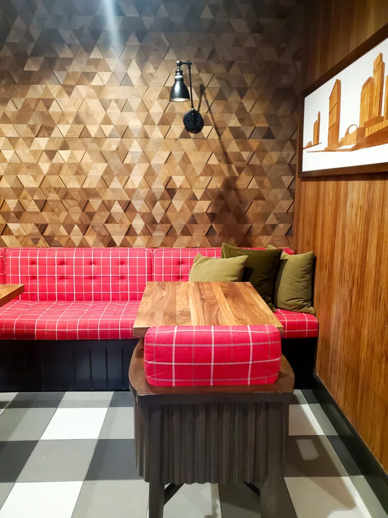 red plaid seating at cafe tables, triangle wood feature wall